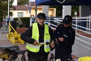 alt=&quot;Policjantka zapina kamizelkę rowerzyście.&quot;