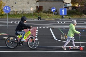 alt=&quot;Dzieci z przedszkola w trakcie korzystania z miasteczka ruchu drogowego.&quot;